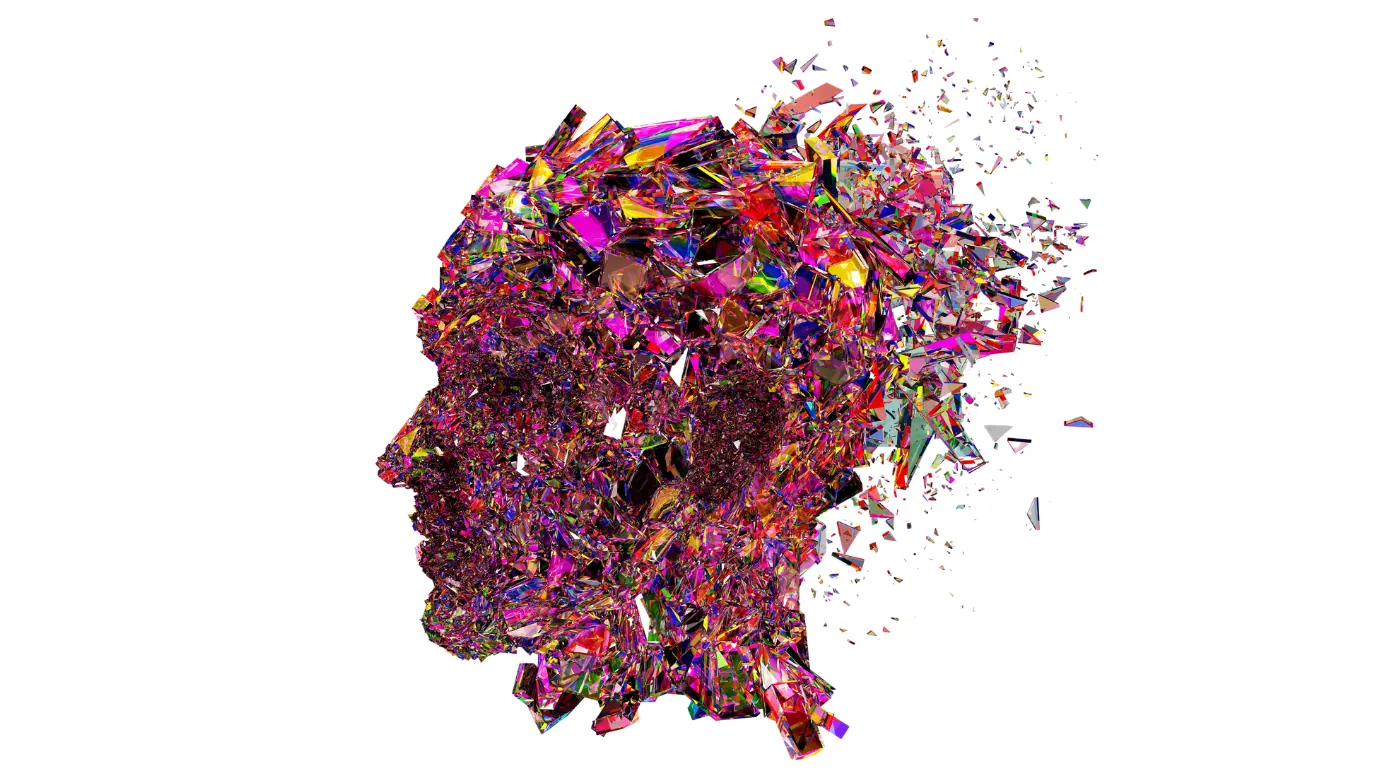 A human head in profile built from thousands of coloured glass shards, dissolving into fragments at the back of the skull