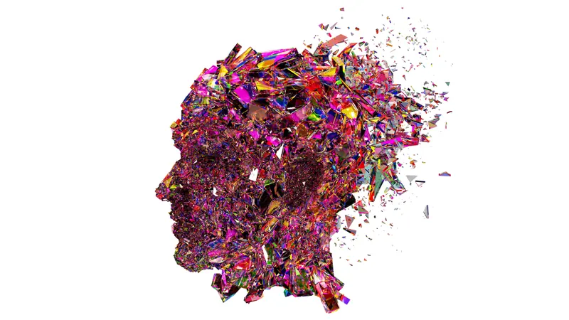 A human head in profile built from thousands of coloured glass shards, dissolving into fragments at the back of the skull
