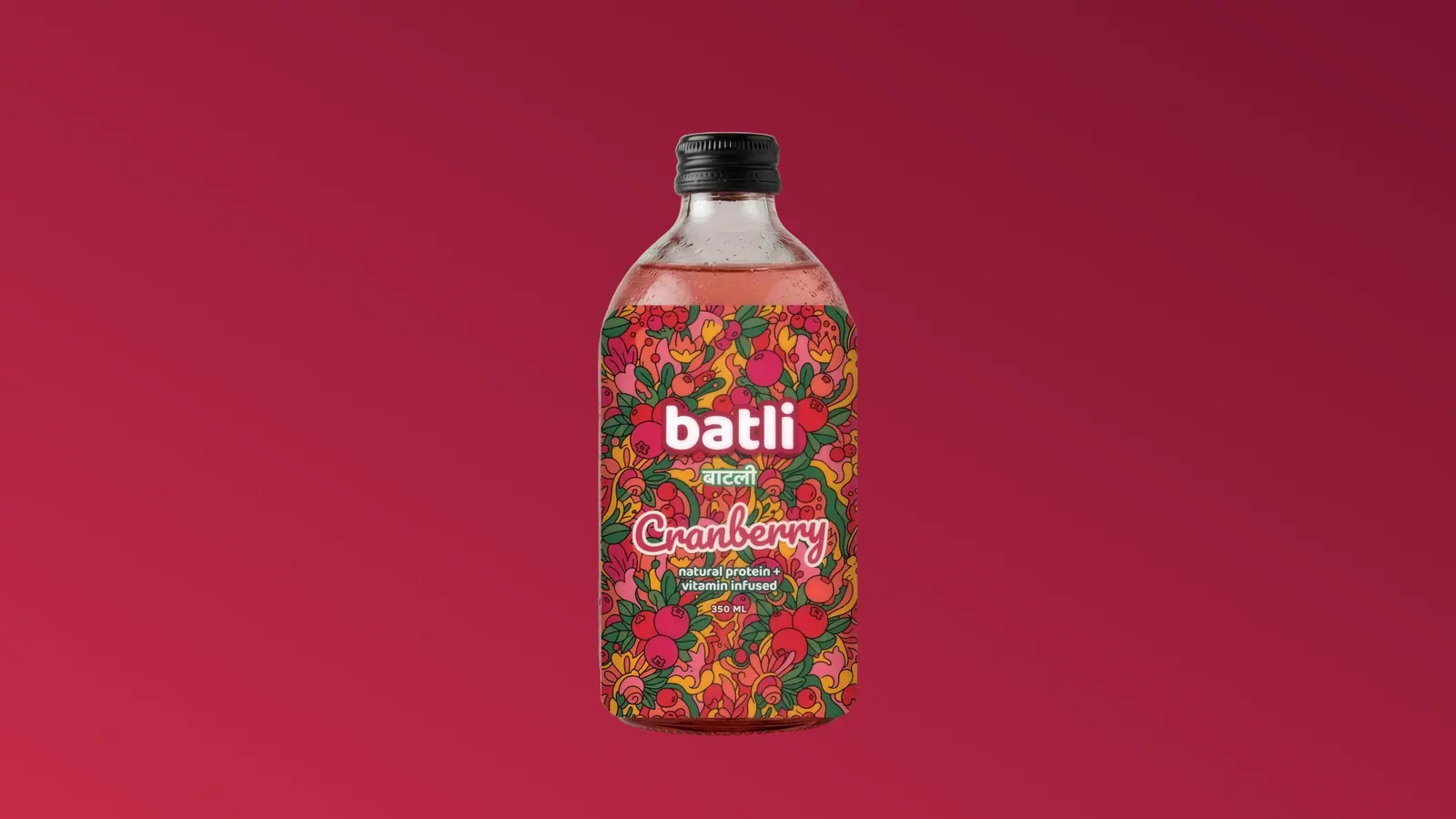 Batli cranberry bottle, its label a dense folk-art field of fruit and flowers